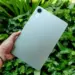 Seseorang memegang tablet Xiaomi Redmi Pad 2 SE dengan latar belakang daun yang segar.