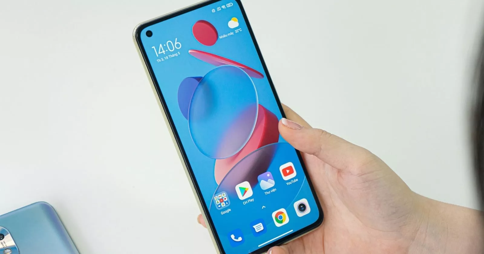 Seseorang memegang smartphone Xiaomi dengan layar menyala menampilkan antarmuka HyperOS.