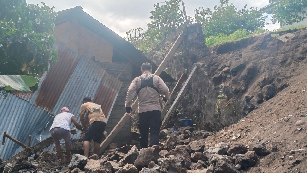 Petugas dan warga melakukan evakuasi di area terdampak longsor akibat Gempa Manado yang dahsyat.