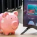 Ilustrasi celengan babi dan remote TV sebagai simbol harga Smart TV murah 2026 yang hemat biaya.