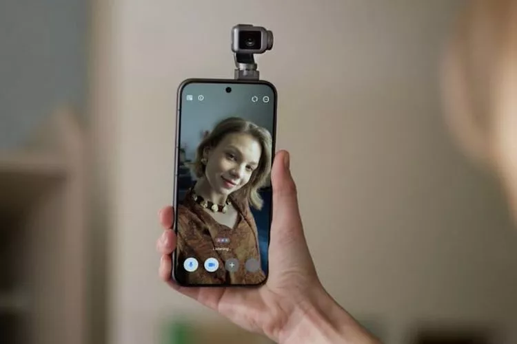 Seseorang memegang Honor Magic 9 yang terpasang aksesori kamera tambahan, menampilkan antarmuka aplikasi kamera dengan potret seorang wanita.