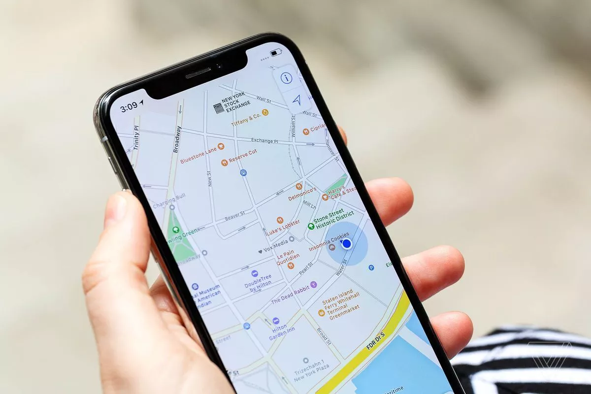Seseorang sedang membuka aplikasi navigasi peta di smartphone untuk melihat detail lokasi.