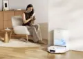 Seorang wanita bersantai di ruang tamu saat Robot Vacuum Xiaomi H50 Series kembali ke stasiun pengisian otomatisnya.