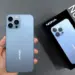 Seseorang memegang smartphone Nokia NX 5G berwarna biru muda beserta kotak kemasan yang menampilkan gambar produk.