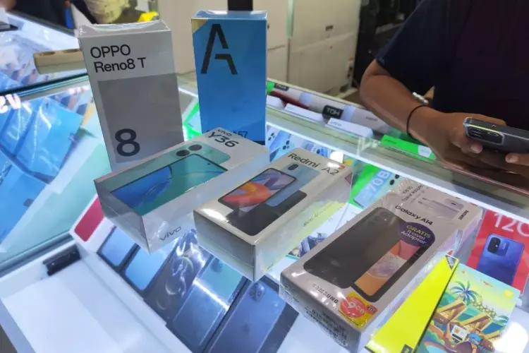 Berbagai kotak smartphone Android terbaru seperti Oppo Reno8 T, Vivo Y36, dan Samsung Galaxy A14 di etalase toko.