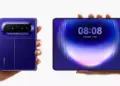 Huawei Pura X Max terlipat dipegang tangan kiri dan layar dalam terbuka lebar dipegang tangan kanan.