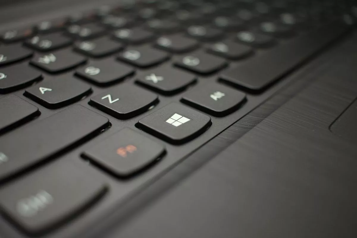 Close-up tombol logo Windows pada keyboard laptop untuk akses menu sistem.