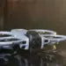 Detail desain bodi drone DJI Avata 360 yang futuristik diletakkan di permukaan reflektif.