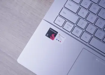 Close-up area palm rest Laptop AI ASUS Vivobook S14 menampilkan stiker 'Powered by Snapdragon X' dan 'Microsoft Office'.