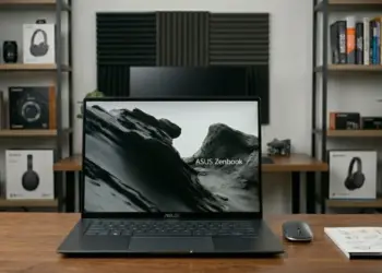 Laptop ASUS Zenbook S16 OLED UM5606GA di atas meja kerja dengan layar menampilkan wallpaper pegunungan