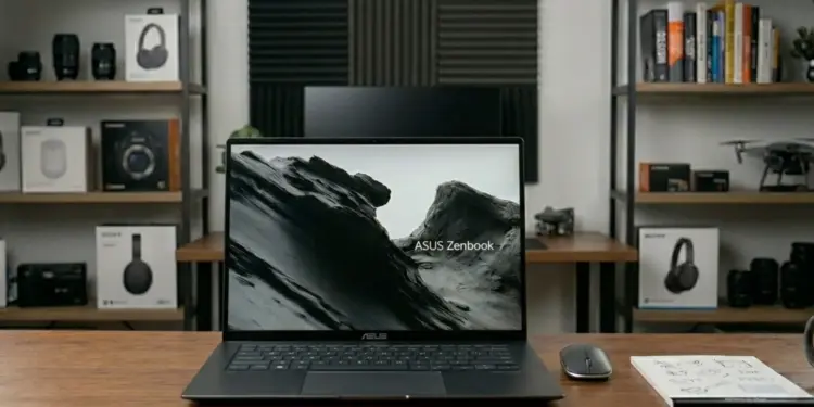 Laptop ASUS Zenbook S16 OLED UM5606GA di atas meja kerja dengan layar menampilkan wallpaper pegunungan