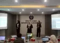 Tiga mahasiswa ITB sedang melakukan presentasi materi mengenai solusi limbah batu bara di hadapan juri dalam sebuah kompetisi kasus industri.