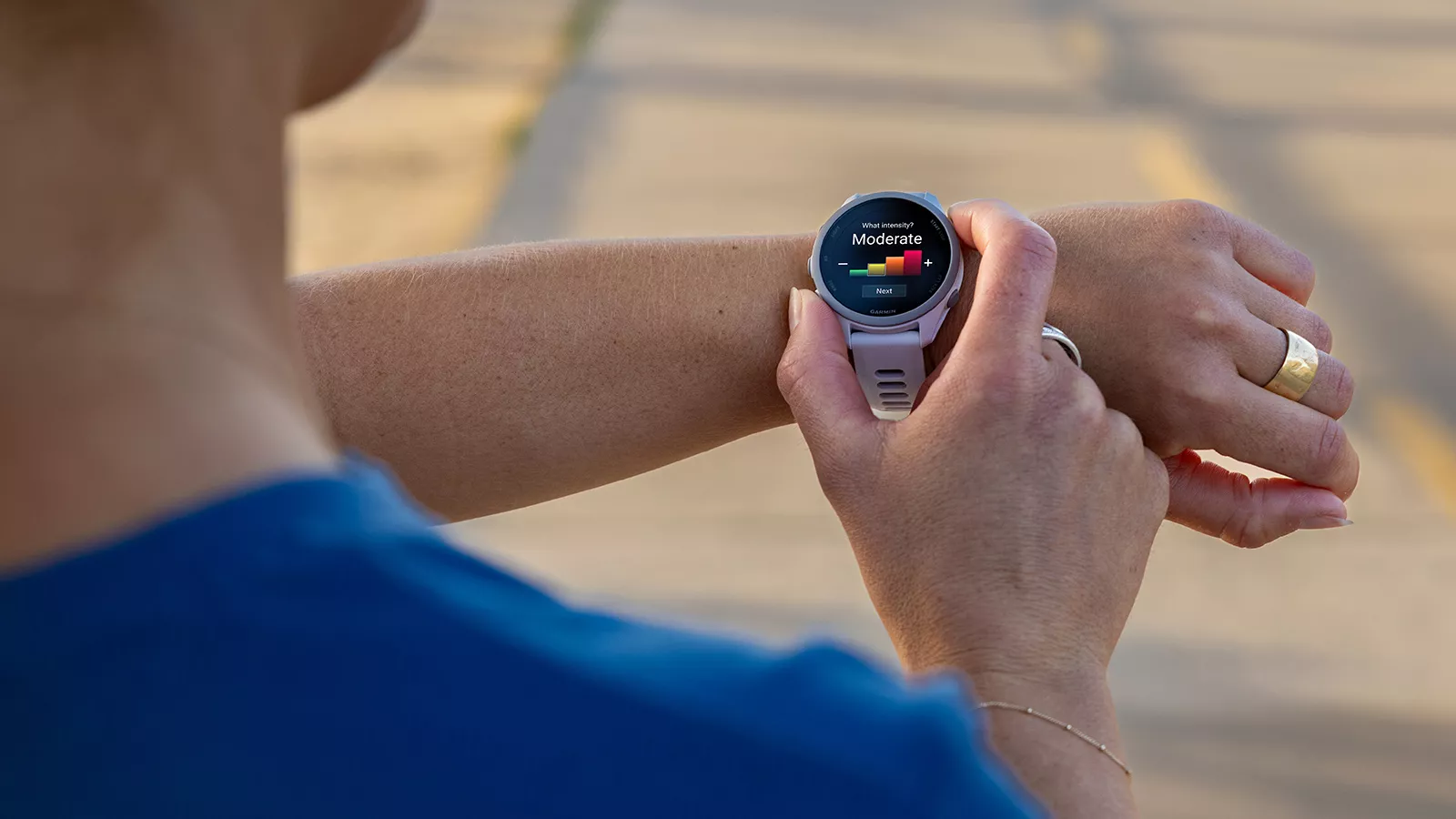 Seseorang menggunakan Garmin Forerunner untuk memantau indikator intensitas latihan "Moderate".