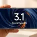 Seseorang memegang smartphone Xiaomi berlayar lengkung yang menampilkan logo Xiaomi HyperOS 3.1 dalam posisi lanskap.