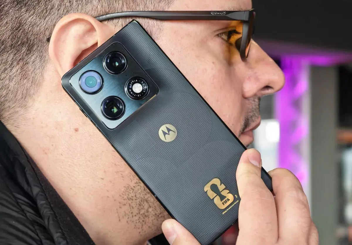 Tampilan detail bodi belakang Motorola Razr Fold FIFA Edition saat digunakan untuk menelepon, menunjukkan tekstur premium dan logo emas.