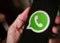 Seseorang memegang smartphone yang menampilkan logo aplikasi WhatsApp di layar untuk reservasi username baru.