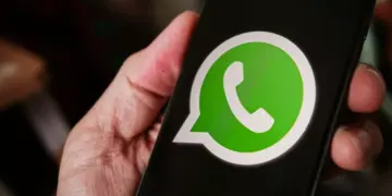 Seseorang memegang smartphone yang menampilkan logo aplikasi WhatsApp di layar untuk reservasi username baru.