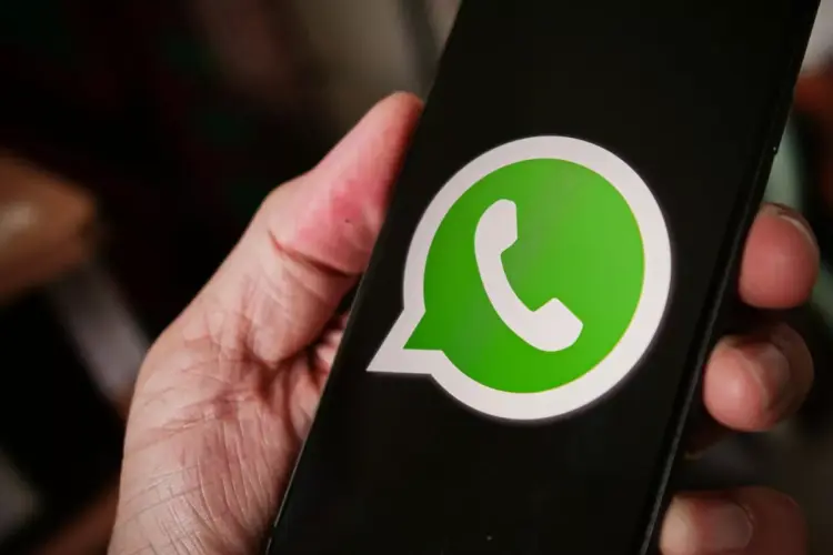 Seseorang memegang smartphone yang menampilkan logo aplikasi WhatsApp di layar untuk reservasi username baru.