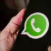 Seseorang memegang smartphone yang menampilkan logo aplikasi WhatsApp di layar untuk reservasi username baru.