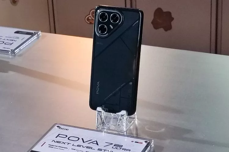 HP Tecno Pova 7 Ultra 5G berwarna hitam dipajang menggunakan stand akrilik bening di atas meja pameran.