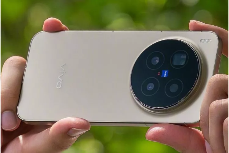 Seseorang menggenggam Vivo X300 Pro varian warna gold secara horizontal untuk mengambil foto atau video dengan lensa ZEISS T Star.