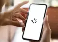 Layar smartphone menampilkan ikon loading berputar yang menandakan HP sering lemot saat membuka aplikasi.