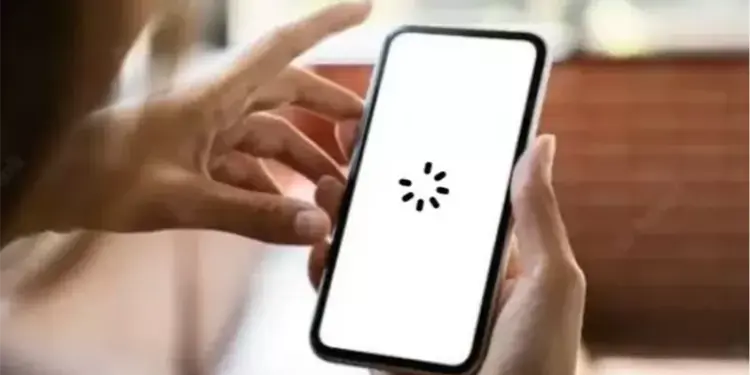 Layar smartphone menampilkan ikon loading berputar yang menandakan HP sering lemot saat membuka aplikasi.
