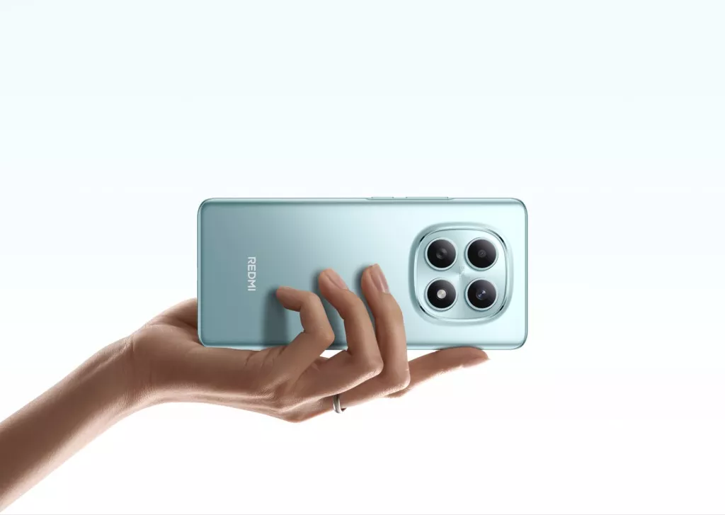 Genggaman tangan pada bodi belakang HP Redmi Midrange terbaru warna hijau muda dengan modul empat lingkaran kamera.
