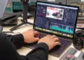 Seseorang sedang melakukan editing video di laptop menggunakan software profesional
