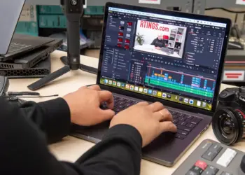 Seseorang sedang melakukan editing video di laptop menggunakan software profesional