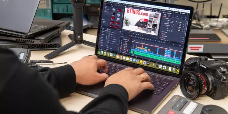 Seseorang sedang melakukan editing video di laptop menggunakan software profesional