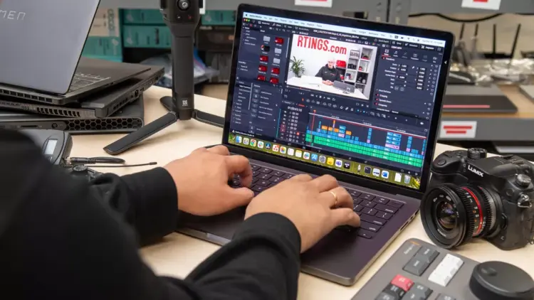 Seseorang sedang melakukan editing video di laptop menggunakan software profesional