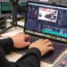 Seseorang sedang melakukan editing video di laptop menggunakan software profesional