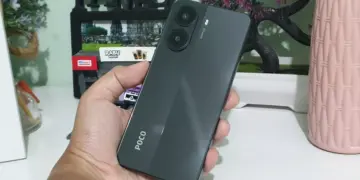 Seseorang memegang smartphone POCO warna hitam abu-abu gelap dengan dua lingkaran kamera besar, pilihan HP memori 512GB terjangkau.