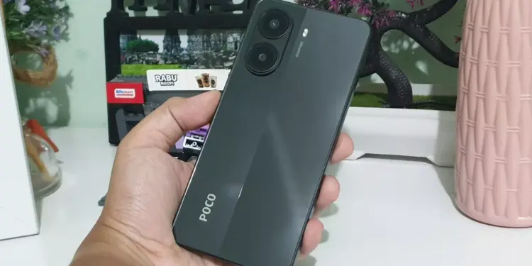 Seseorang memegang smartphone POCO warna hitam abu-abu gelap dengan dua lingkaran kamera besar, pilihan HP memori 512GB terjangkau.