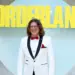 Randy Pitchford mengenakan jas putih tersenyum di depan logo Borderlands, merefleksikan asal usul bocoran aneh Pixel Watch 5.