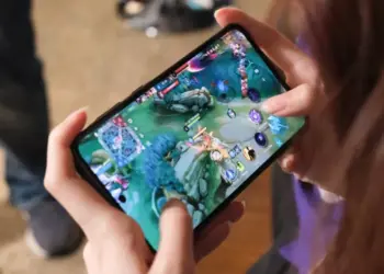 Seseorang sedang memegang smartphone dan asyik bermain game Mobile Legends di peta Land of Dawn.