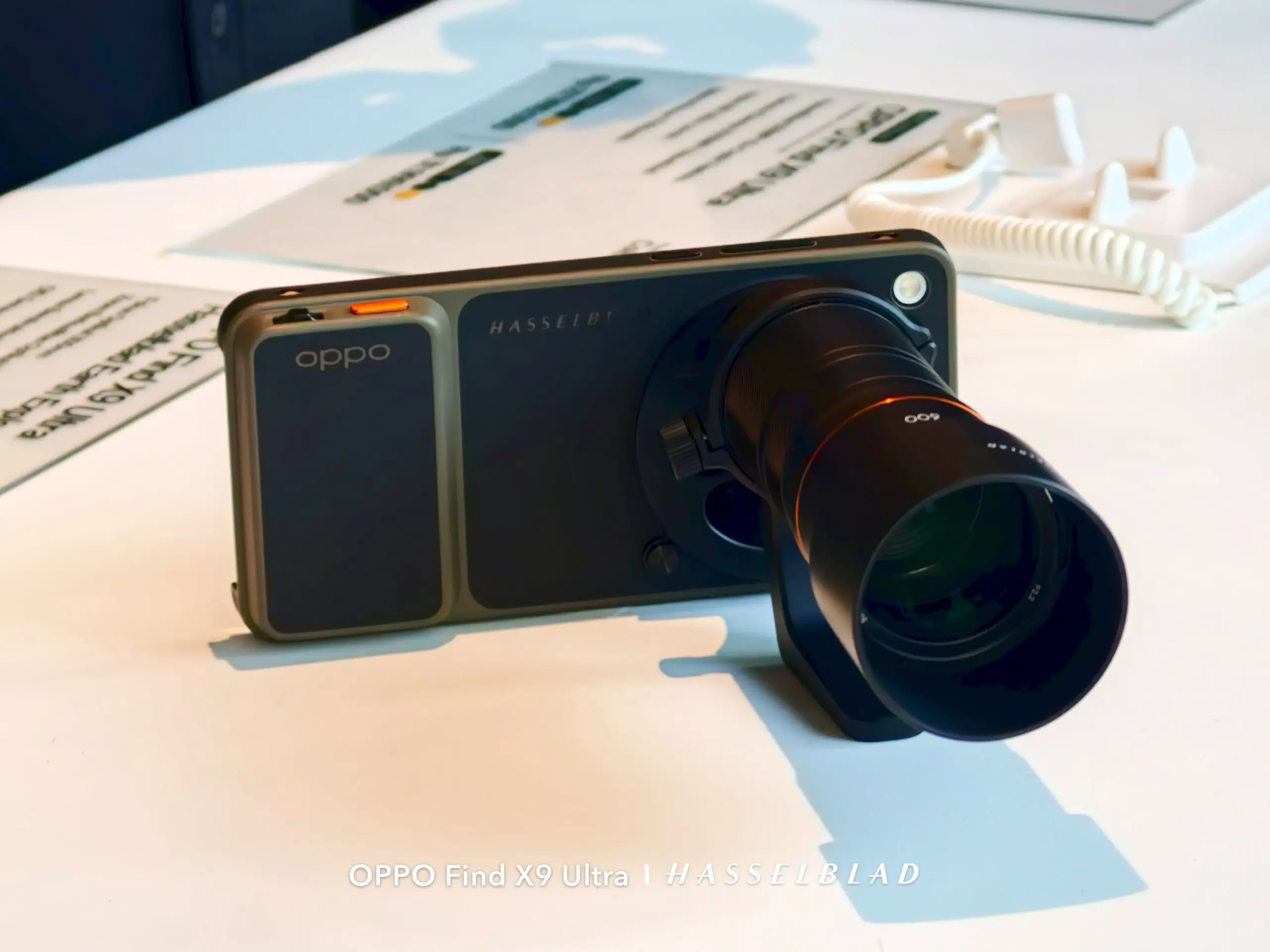 Kamera flagship OPPO Find X9 Ultra saat dipasangkan dengan aksesoris lensa kamera eksternal Hasselblad di meja pameran.