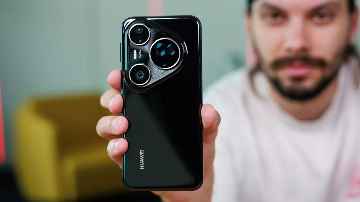 Seorang reviewer pria memegang smartphone flagship Huawei hitam dengan modul kamera berbentuk segitiga unik bermerek XMAGE.