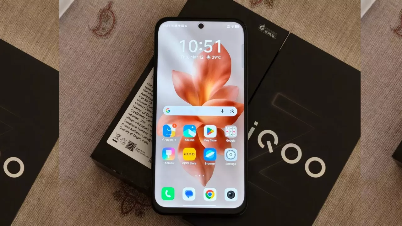 Layar depan HP iQOO terbaru dalam kondisi menyala, menampilkan antarmuka Funtouch OS di atas kotak penjualan hitam bertuliskan iQOO.