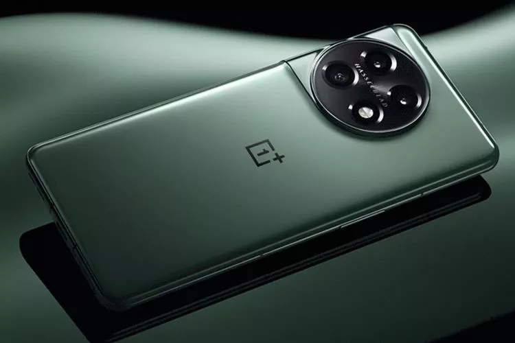 Sisi belakang smartphone OnePlus berwarna hijau dengan modul kamera bulat besar Hasselblad di atas permukaan reflektif.