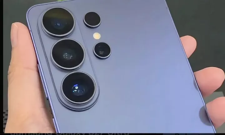 Tampilan langsung hands-on bagian belakang smartphone Galaxy S27 Ultra berwarna ungu pastel dalam genggaman tangan.