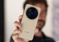 Seseorang sedang memegang Vivo X500 Pro Max varian warna gold, memperlihatkan detail modul kamera Zeiss T* secara langsung.