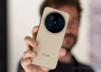 Seseorang sedang memegang Vivo X500 Pro Max varian warna gold, memperlihatkan detail modul kamera Zeiss T* secara langsung.