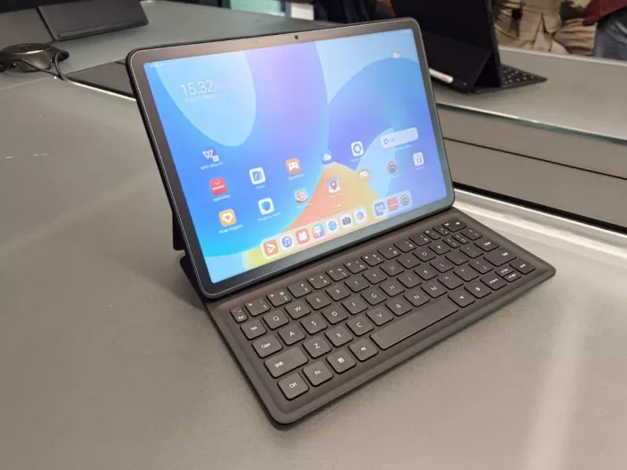 Sebuah tablet SIM card terbaik yang sedang menyala terpasang pada case keyboard eksternal di atas meja kerja.