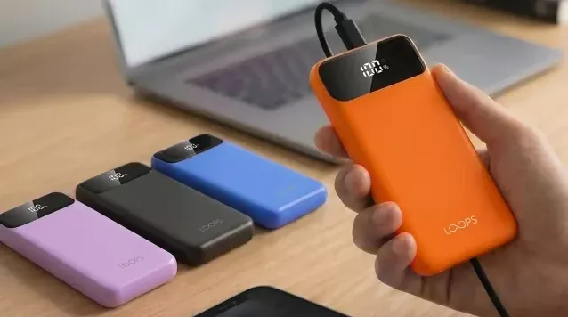 Genggaman tangan pada Powerbank Loops 10.000mAh warna oranye yang sedang terhubung ke kabel, dengan deretan warna ungu, hitam, dan biru di sebelahnya.