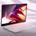 Laptop merk Advan berwarna putih dengan layar menyala terang menampilkan grafis warna-warni yang estetik.