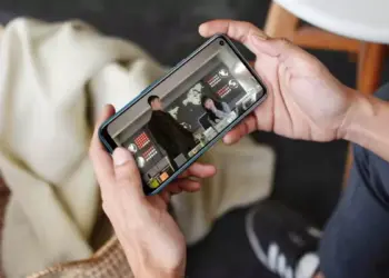 Pengguna smartphone sedang menikmati tayangan video drama dalam posisi landscape di perangkat HP layar berkualitas.