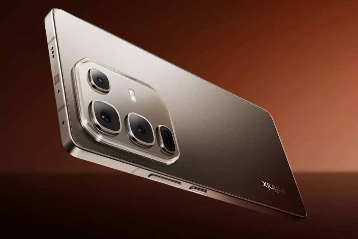 Detail modul kamera belakang HP Infinix premium berwarna emas kecokelatan dengan setup lensa besar dan logo audio JBL di sisi bingkai.