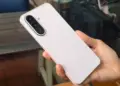 Tampilan bodi belakang Samsung Galaxy A27 5G berwarna merah muda lembut saat digenggam tangan.